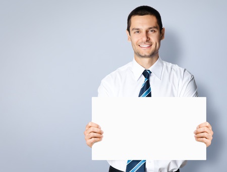 Stock photo of young businessman holding up a sign.