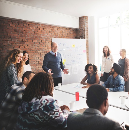 Stock photo of team of employees speaking at a business meeting. 