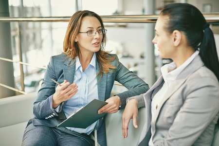 Stock photo of two woman in conversation or a dialogue showing eye contact and listening.