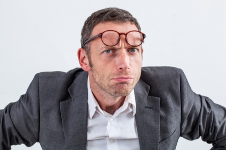 Stock photo of man with glasses on head illustrating body language disapproval.