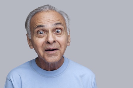 Stock photo of senior Asian man with wide-eyed facial expression.