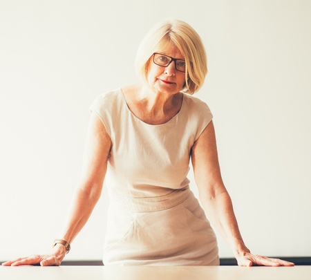 Stock photo of mature business woman in front of whiteboard.