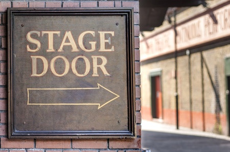 Image of sign reading stage door at a theater.