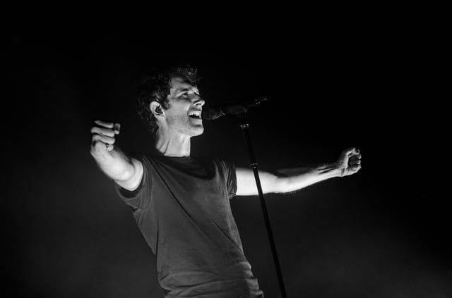 Stock black & white photo of actor gesturing on a stage.