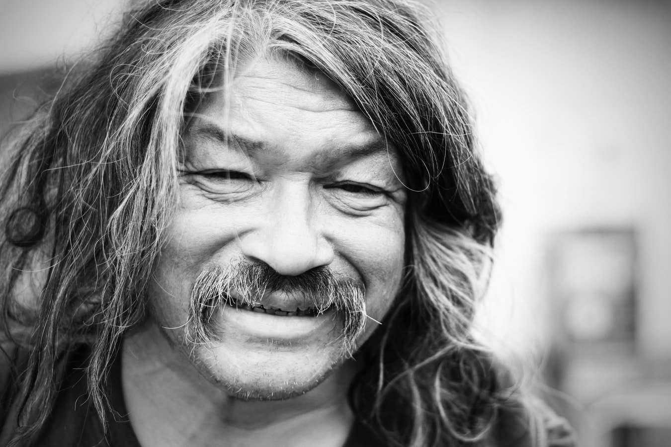 Stock photo of smiling man with long hair and moustache.