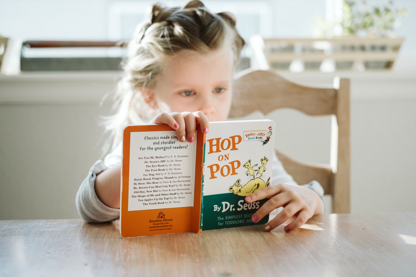 Stock photo of young girl reading a children's book.