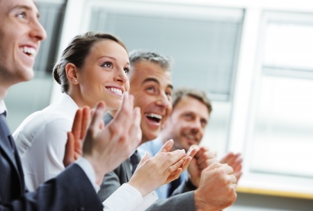 Stock photo of audience applauding with businessman and business woman.